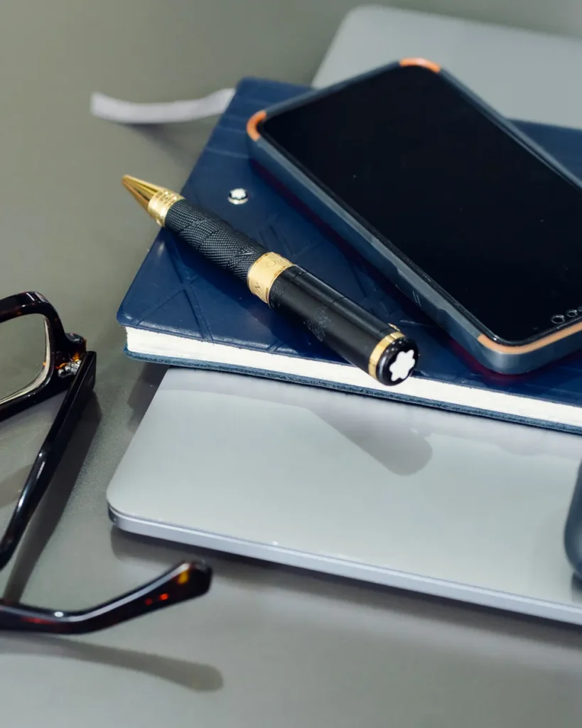 Cuaderno, pluma y agenda sobre el escritorio